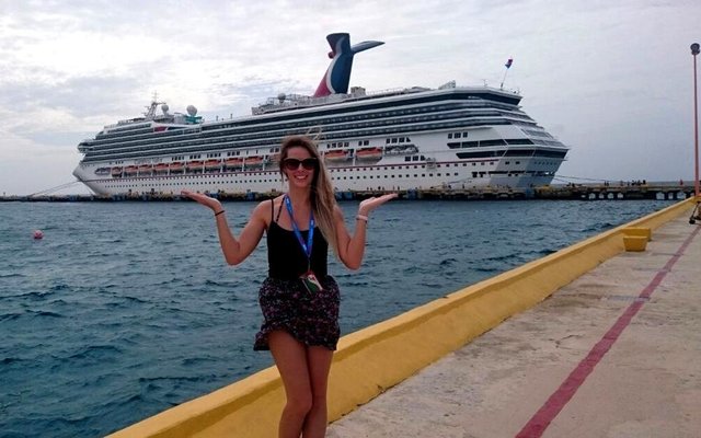  Michelle Hayes, 3 jaar later in 2015 wuif vir Gansbaai as ‘n gekwalifiseerde Ionithermie terapeut, met die boot waarop sy werk, die Carnival Valor agter haar 